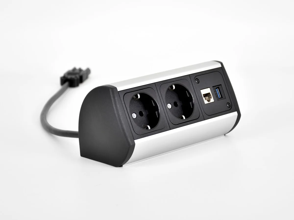 Extensão elétrica compacta com entrada de rede Ethernet e porta USB sobre fundo branco