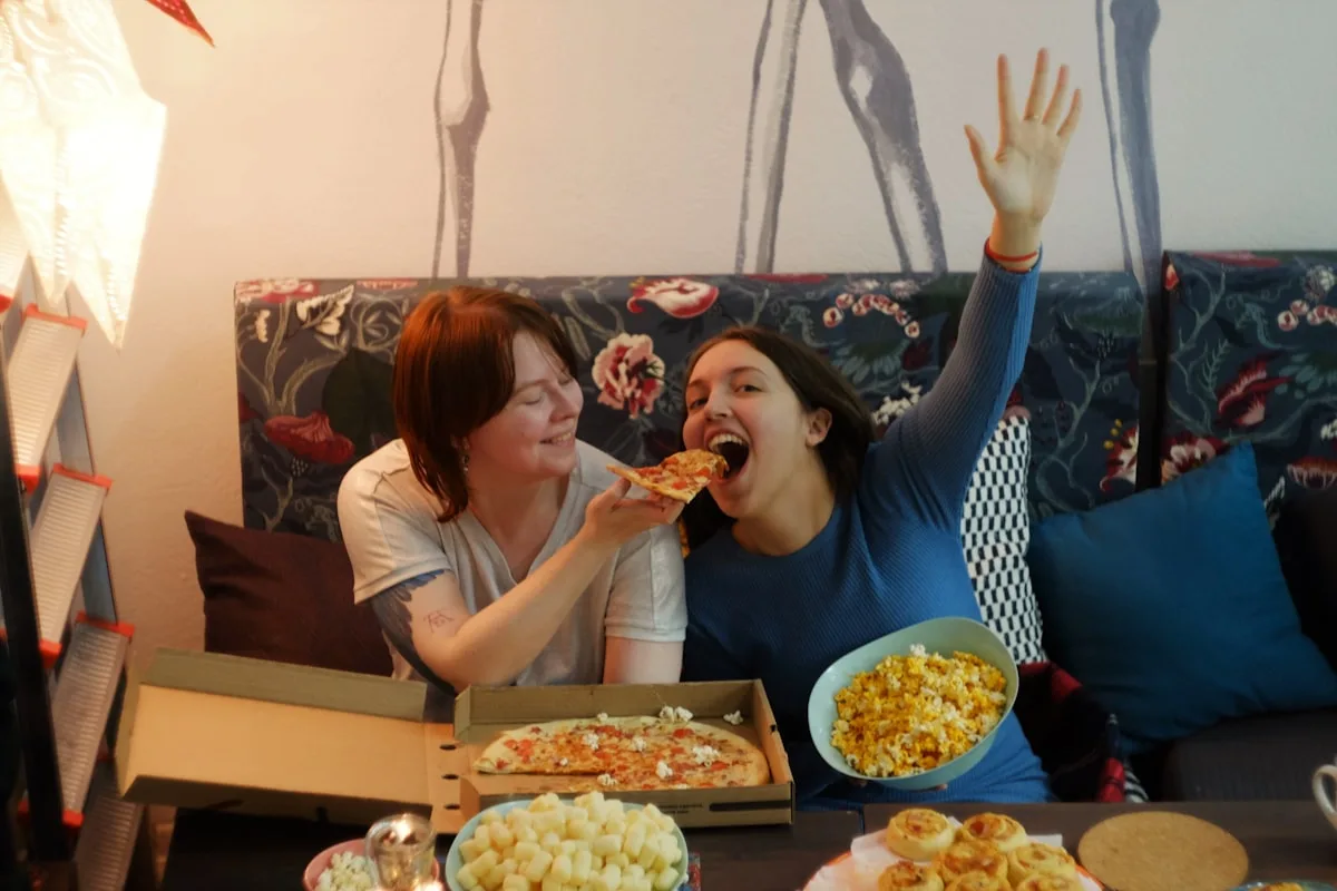 Grupo de amigos comendo pizza e pipoca durante uma sessão de jogos em grupo