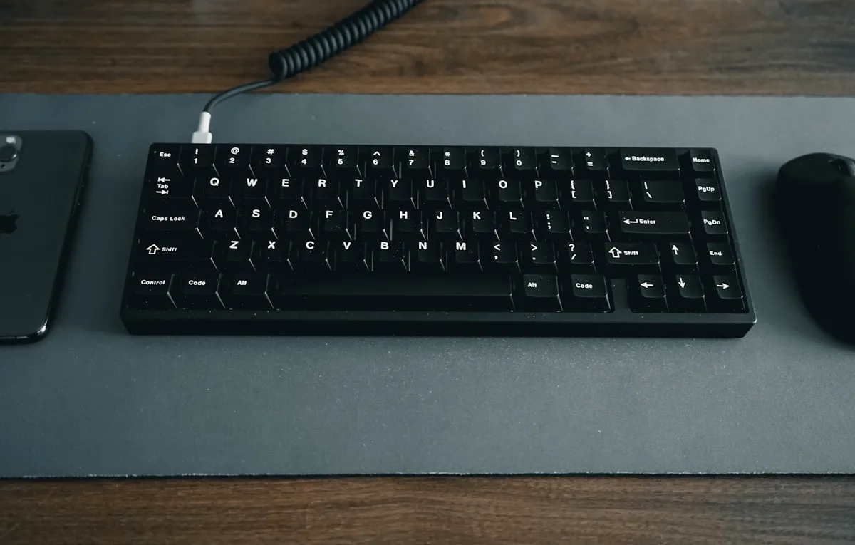 Mousepad grande XL: setup limpo com teclado e mouse sobre o mesmo pad Setup gamer com mousepad extended XL cobrindo teclado e mouse sobre mesa iluminada