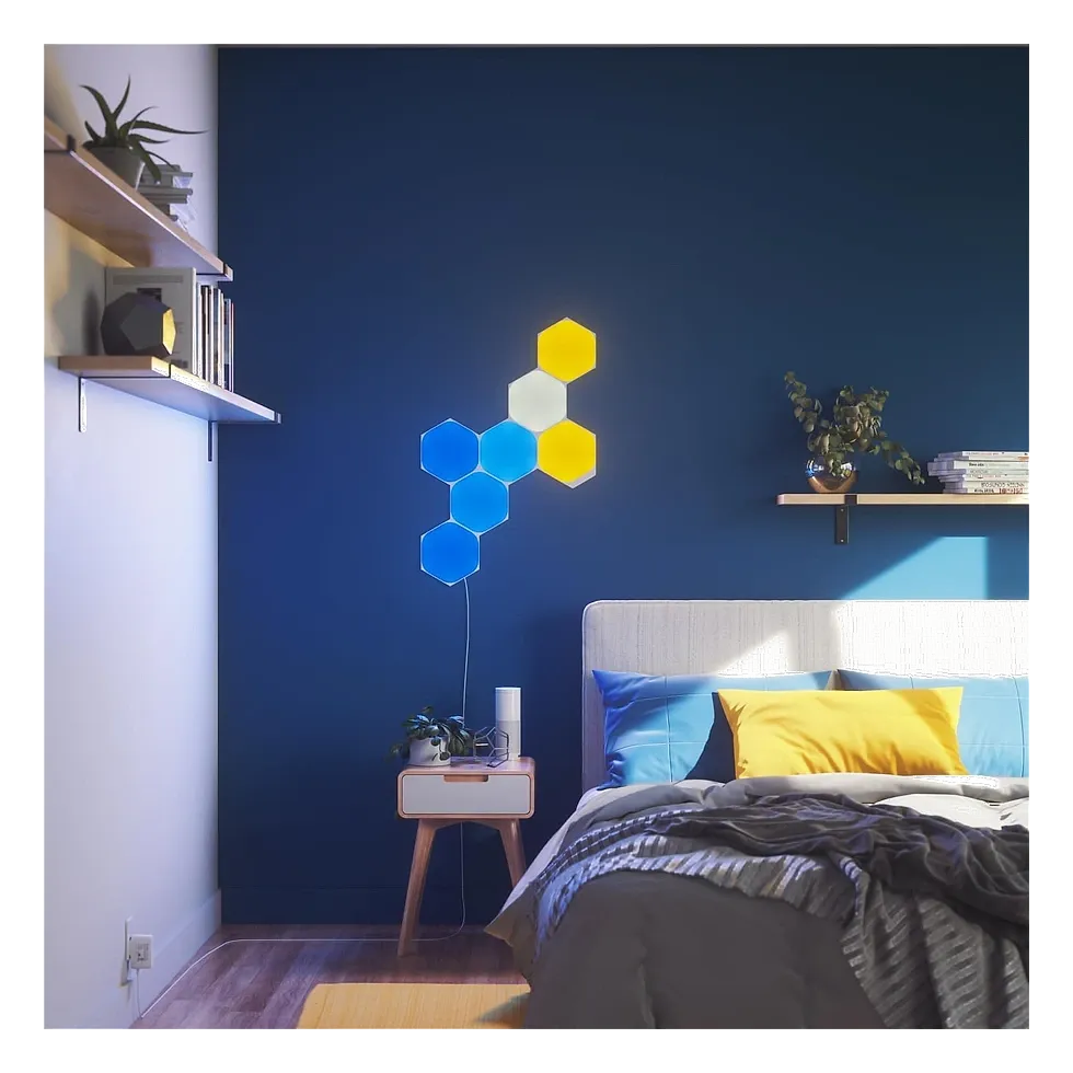 Painéis hexagonais Nanoleaf iluminados em azul e amarelo montados na parede do quarto