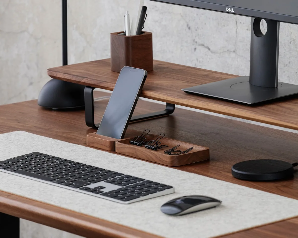 Mesa organizada com suporte de monitor e espaço liberado para acessórios Mesa de escritório organizada com suporte elevado para monitor, teclado e organizador de cabos