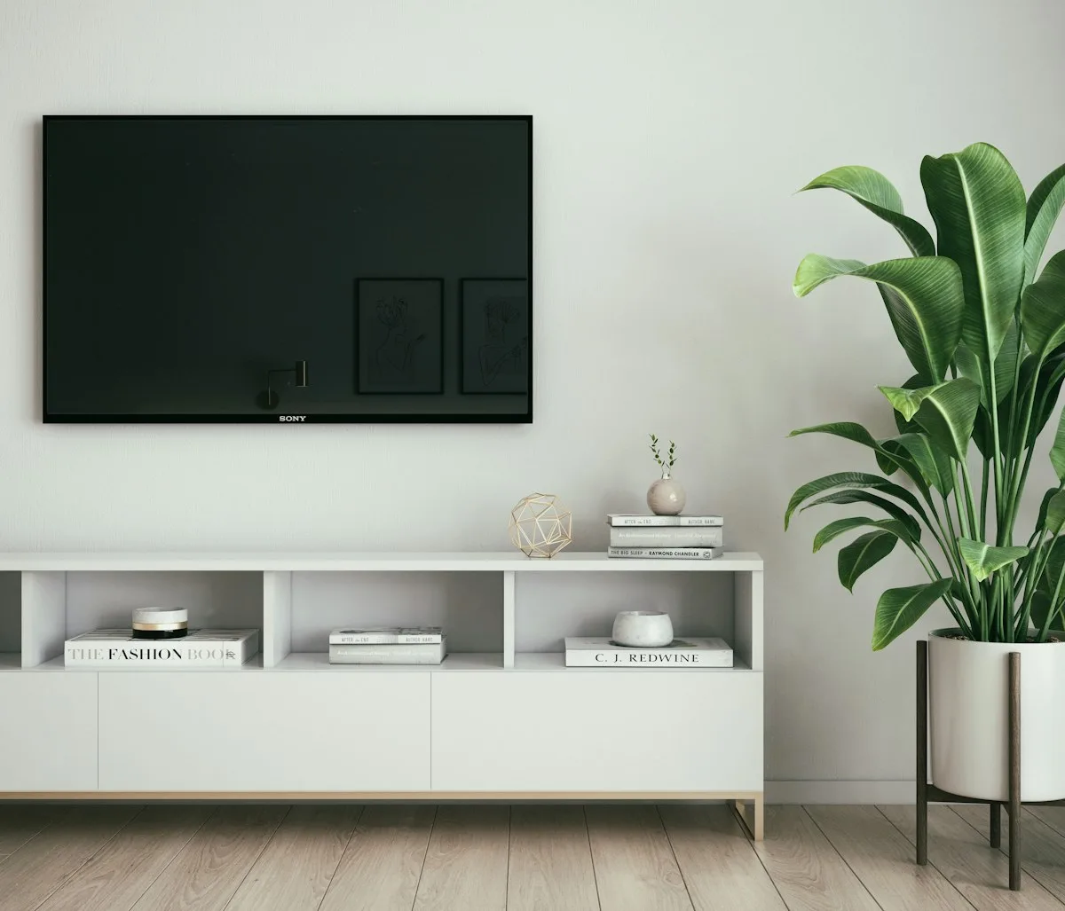 Tela fixada na parede via suporte compatível com VESA TV fixada na parede de uma sala de estar organizada, sustentada por suporte compatível com o padrão VESA