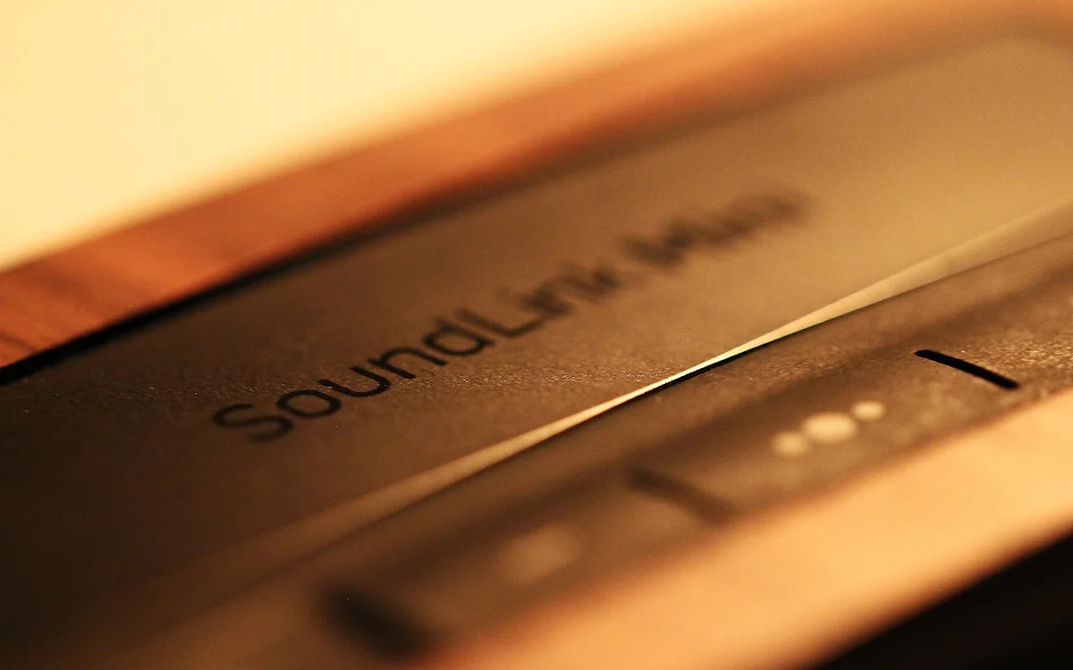 Soundbar com subwoofer sem fio e módulos de caixa traseira dispostos em sala de home theater