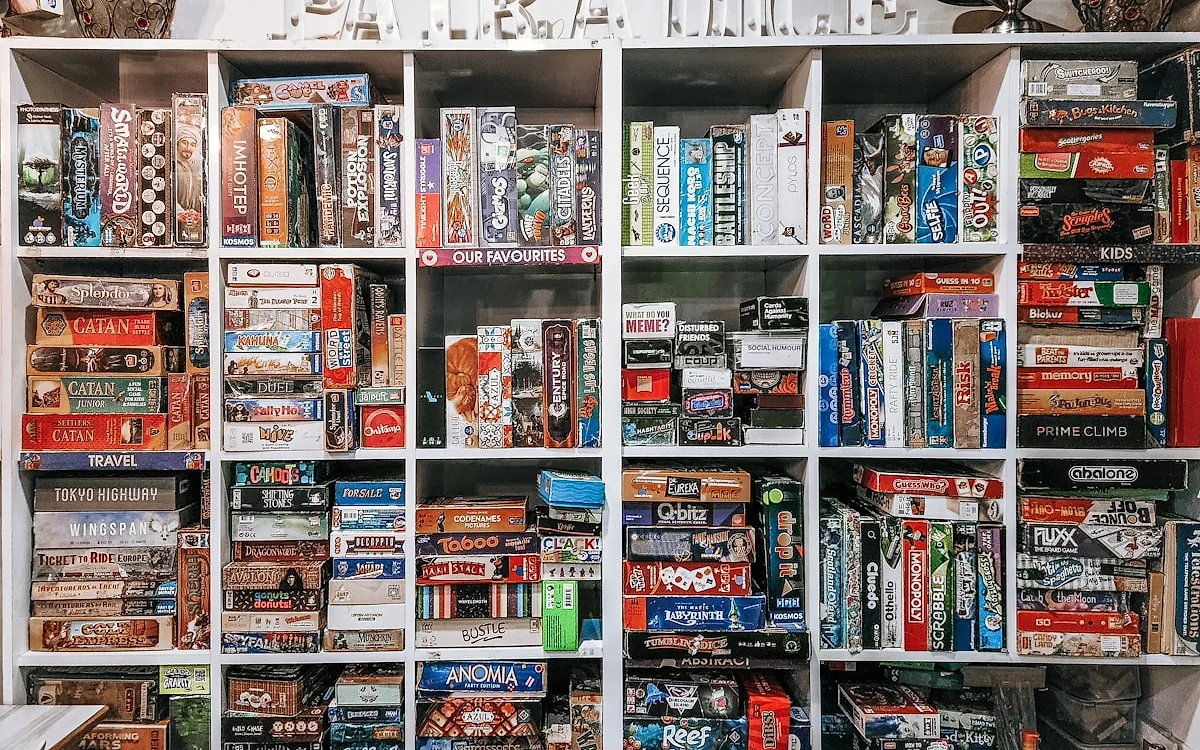 Loja especializada em jogos Estante organizada de loja especializada em jogos, com prateleiras cheias de caixas divididas por categoria