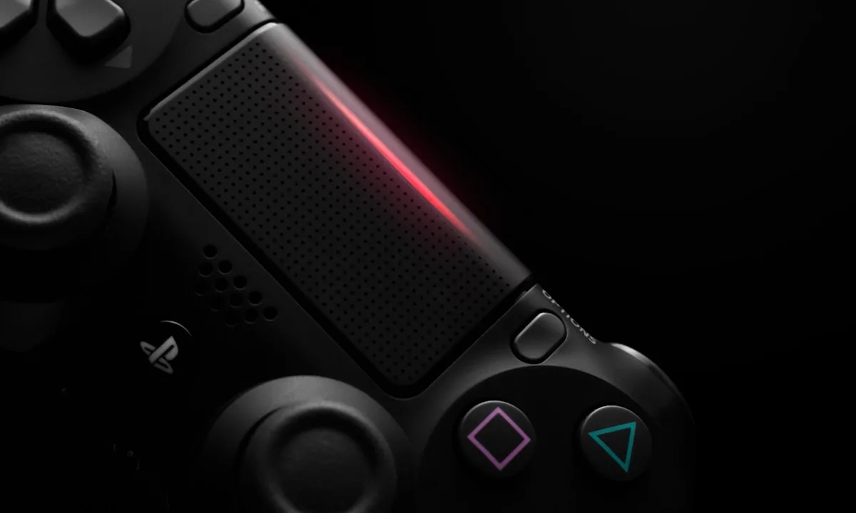 Detalhe do controle PlayStation Close do touchpad e dos botões de um controle PlayStation em ambiente escuro com luz vermelha