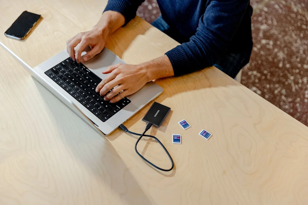 Adaptador USB-C compacto sobre mesa de trabalho ao lado de notebook
