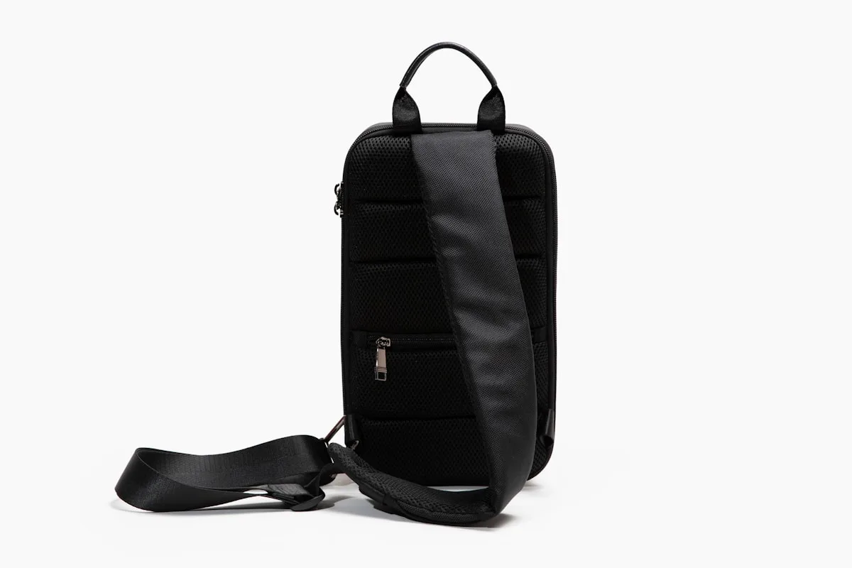Mochila preta vista de trás mostrando alça acolchoada ajustável e painel traseiro estofado em malha