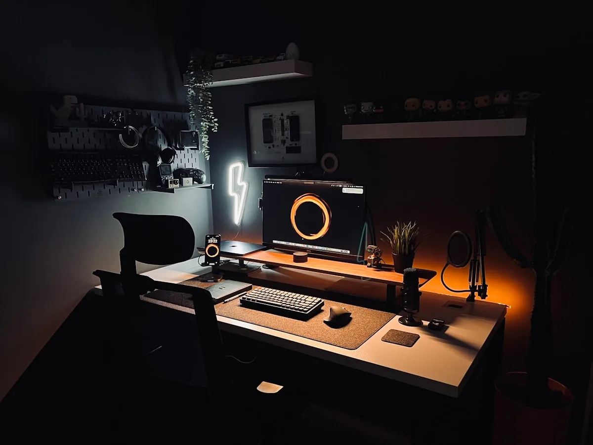 Iluminação RGB decorativa no setup Mesa gamer escura com luminária e letreiro de neon acesos, exemplo de RGB decorativo externo