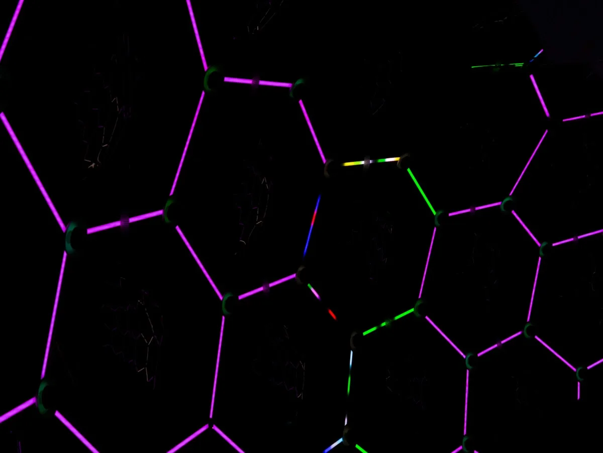 Padrão hexagonal com bordas iluminadas em roxo e verde, lembrando painel de luz modular
