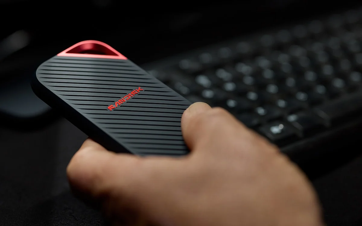 SSD portátil com carcaça de silicone caindo sobre superfície, demonstrando resistência a impacto