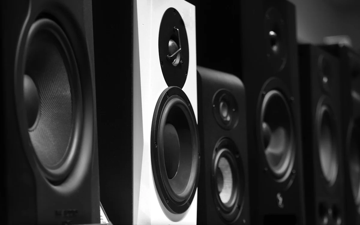 Sala de estar com soundbar sob TV grande e setup de áudio organizado