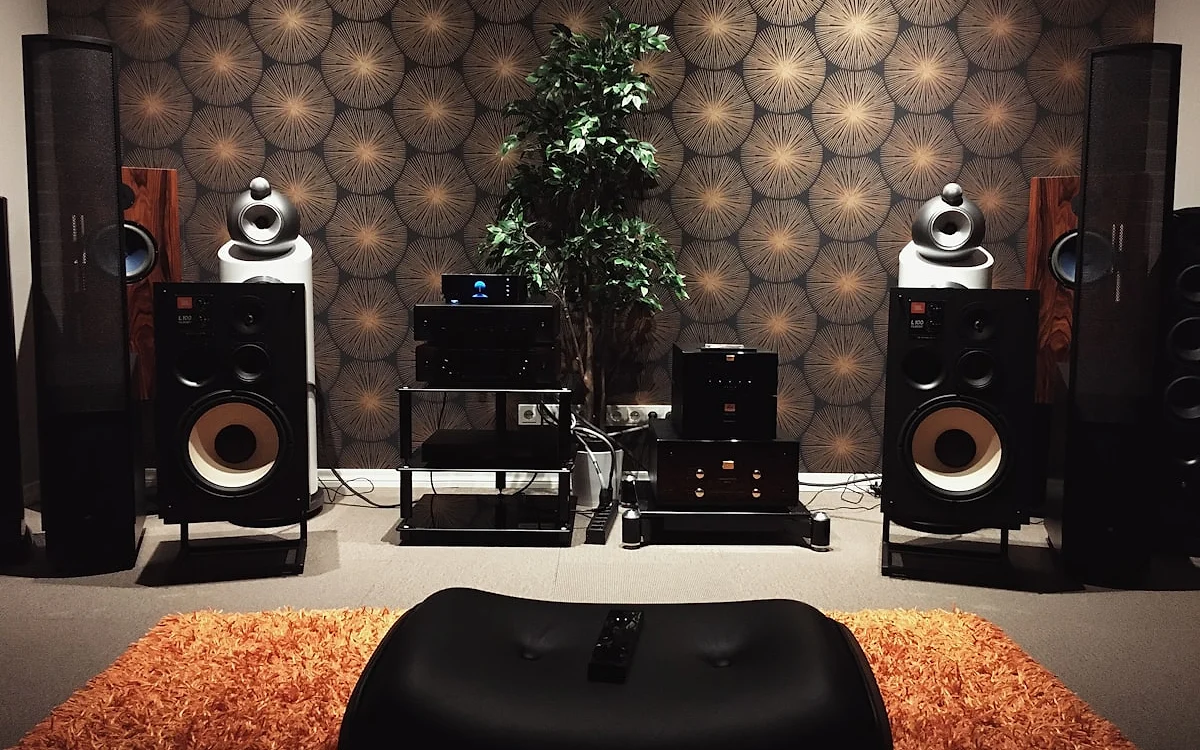 Sala de home theater com caixas surround posicionadas ao redor do sofá central