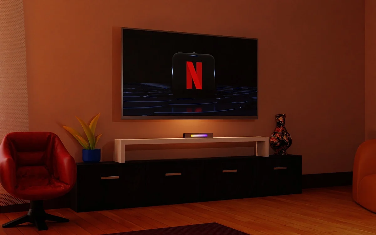 Quando a soundbar faz diferença de verdade Pessoa assistindo a filme de ação em sala grande com soundbar e subwoofer posicionados