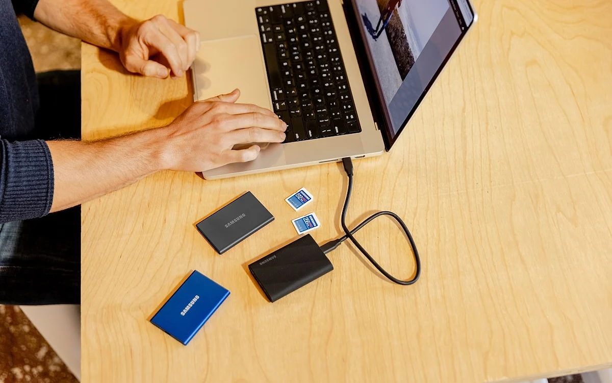 Comparativo lado a lado de SSDs externos compactos para notebook em cima de uma mesa