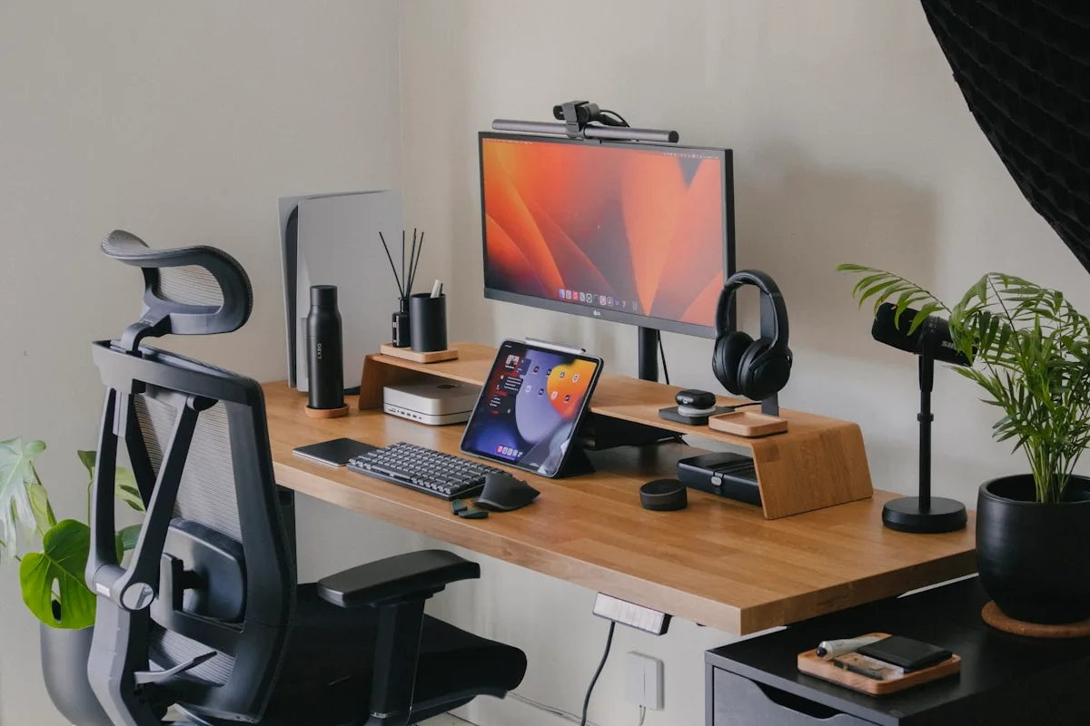 Mesa de canto: cenário onde 2 suportes simples costumam encaixar melhor que 1 duplo Setup de mesa de canto em madeira com monitor único, cadeira ergonômica e acessórios organizados