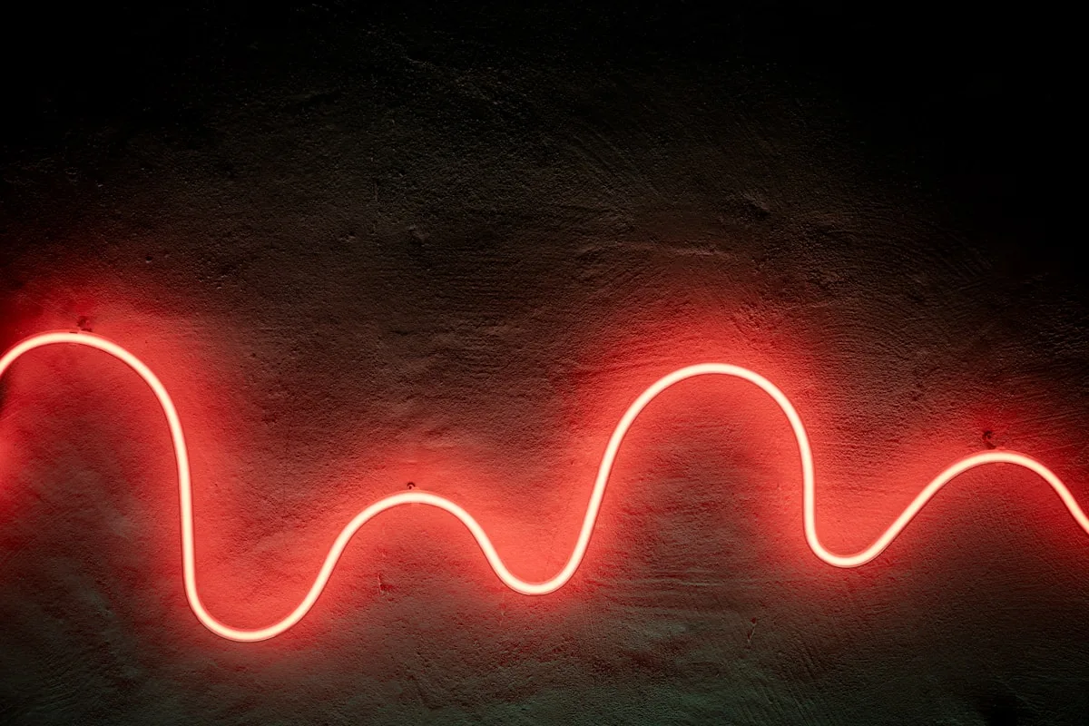 Fita de LED vermelha em formato de ondas contínuas sobre parede escura, fita RGB simples