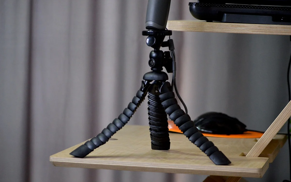 Os melhores tripés e suportes para webcam em 2026 Webcam posicionada no nível dos olhos com suporte ajustável em setup de streaming com microfone e ring light