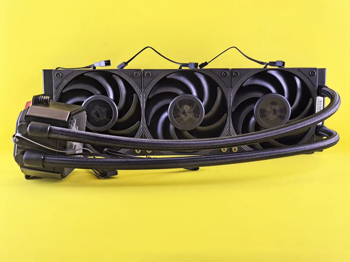 AIO de 360 mm Radiador de water cooler de 360 mm visto de frente, com ventoinhas pretas e mangueiras trançadas conectadas ao bloco