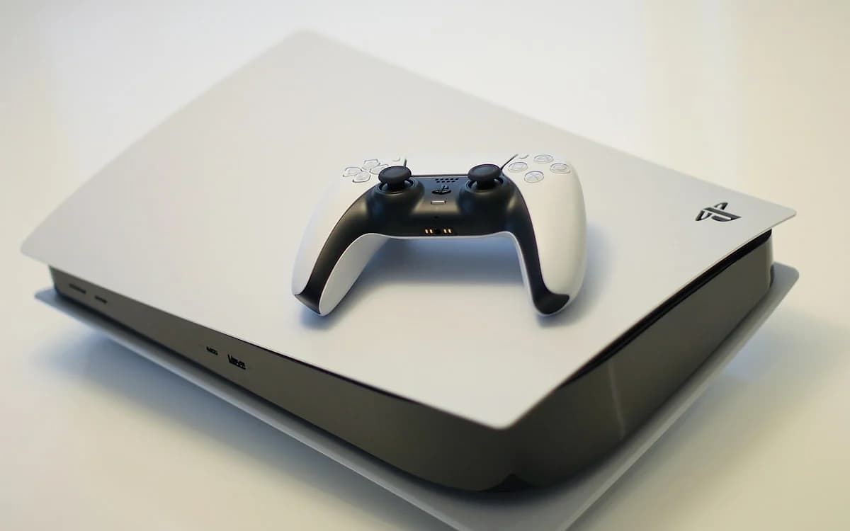 Acessórios para PS5 em 2026: Os Essenciais que Valem a Pena PS5 e PS5 Pro em setup com SSD NVMe, base de carregamento DualSense e acessórios essenciais ao redor