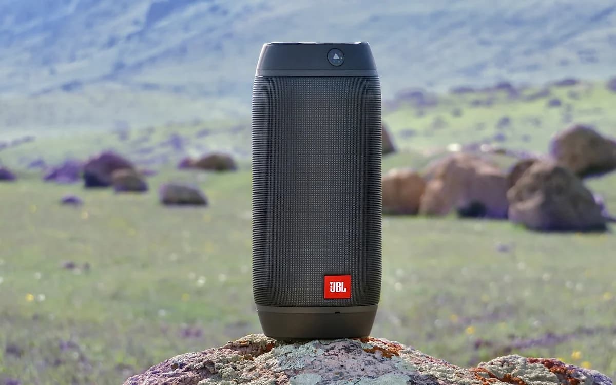 Caixa de Som JBL Vale a Pena em 2026? Caixa de som JBL portátil Bluetooth sobre superfície ao ar livre com cores vibrantes