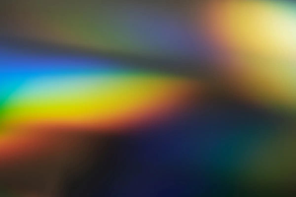 DLP ou LCD para Jogos em 2026 Feixes de luz difusos em tons de azul, verde e amarelo cruzando na diagonal, lembrando um efeito prisma