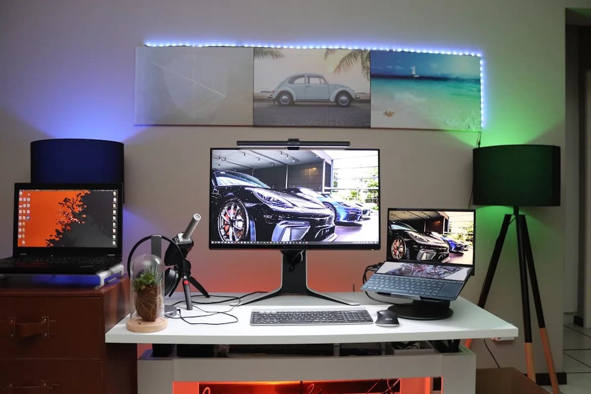 Fita LED RGB vale a pena em 2026 Fita de LED RGB azul e verde iluminando a parede atrás de monitores em setup gamer decorado à noite