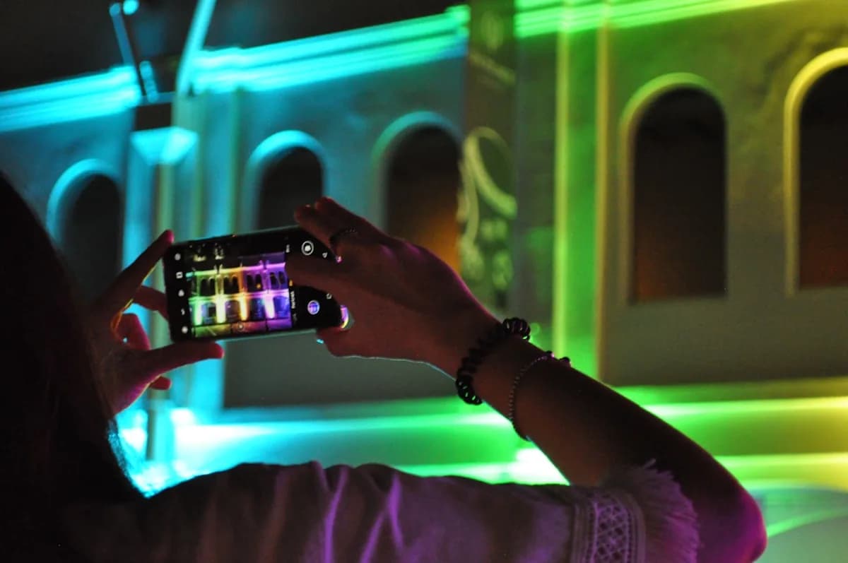Review Govee Fita LED RGBIC em 2026 Smartphone capturando fachada iluminada em tons de azul, verde e roxo à noite