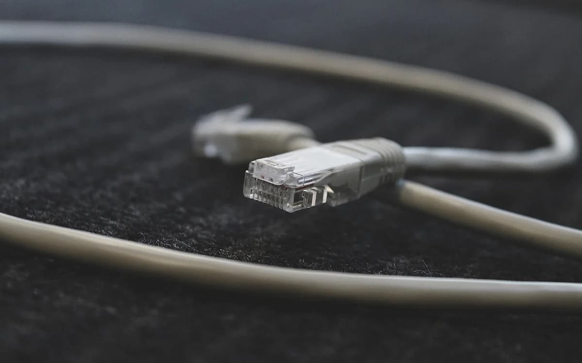 Melhor Cabo de Rede para Jogos em 2026 Cabo de rede Ethernet conectado a um roteador em um setup gamer