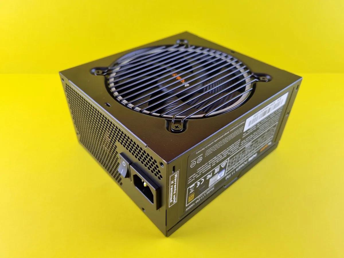 Melhor fonte PC gamer até R$400 em 2026 Fonte de alimentação preta para PC com cabos e conector ATX sobre mesa de montagem