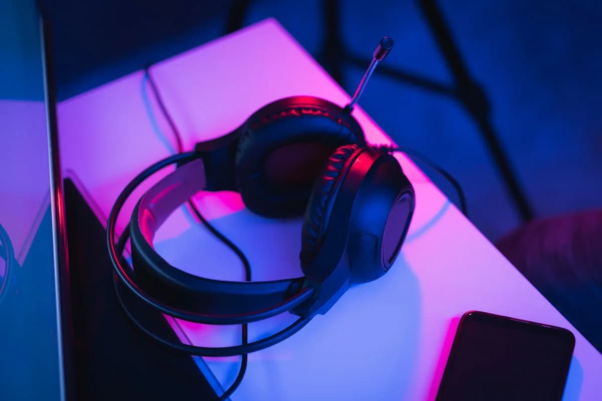Melhor headset gamer HyperX 2026 Setup gamer com headset over-ear preto sobre mesa com teclado mecânico RGB