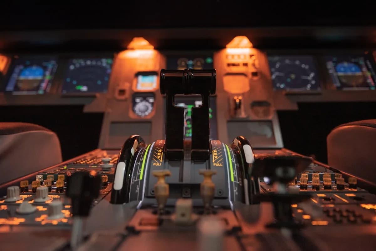 Melhor Joystick para Simulador de Voo até R$ 1.000 Quadrante de aceleradores de cabine de avião iluminado em tom laranja, com painéis ao fundo