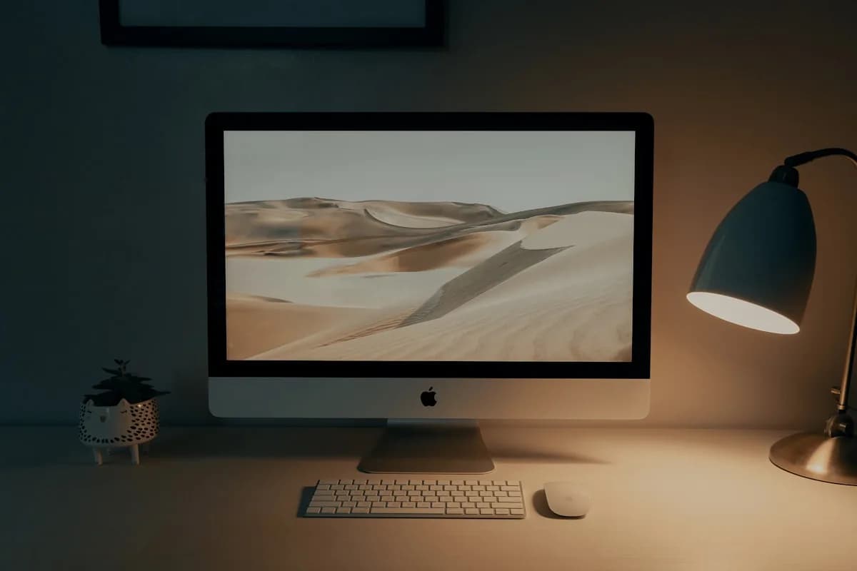 Melhor Luz de Fundo para Monitor em 2026 Monitor de computador em quarto escuro com brilho ambiente suave saindo de trás da tela