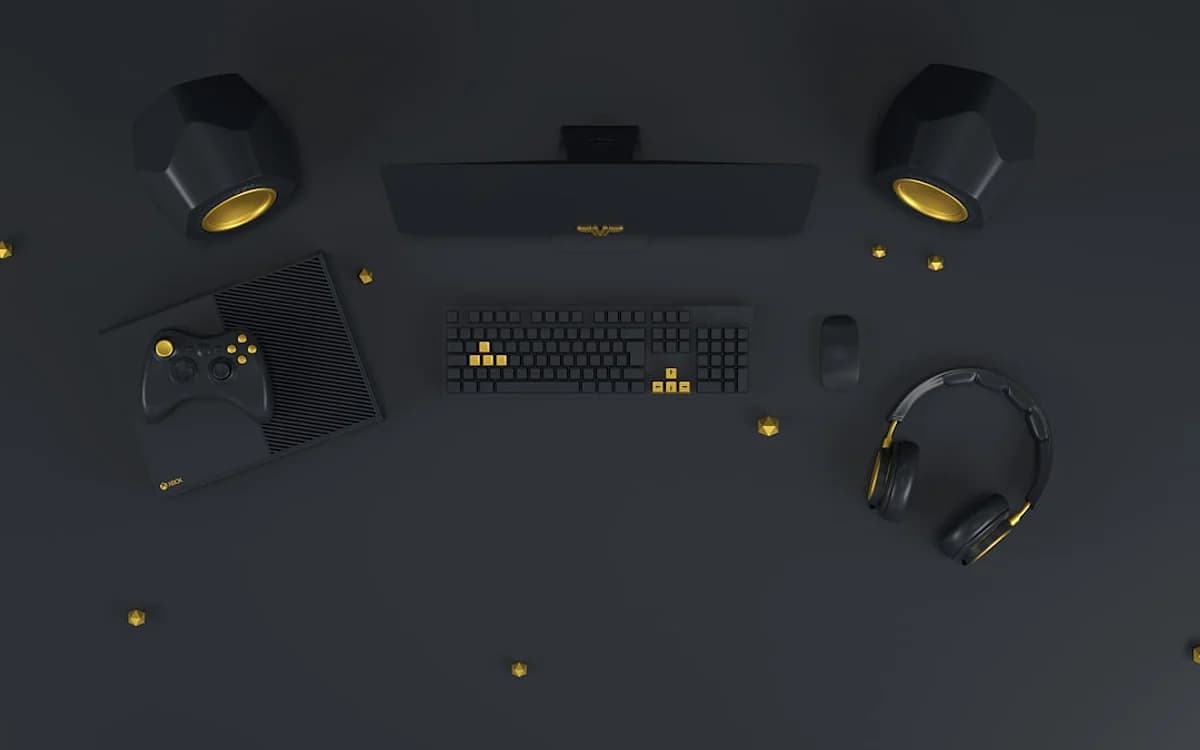 Melhor Mini PC Beelink 2026: SER, EQ ou Mini S? Teclado, mouse, headset, controle e caixas de som em preto e dourado vistos de cima sobre mesa escura