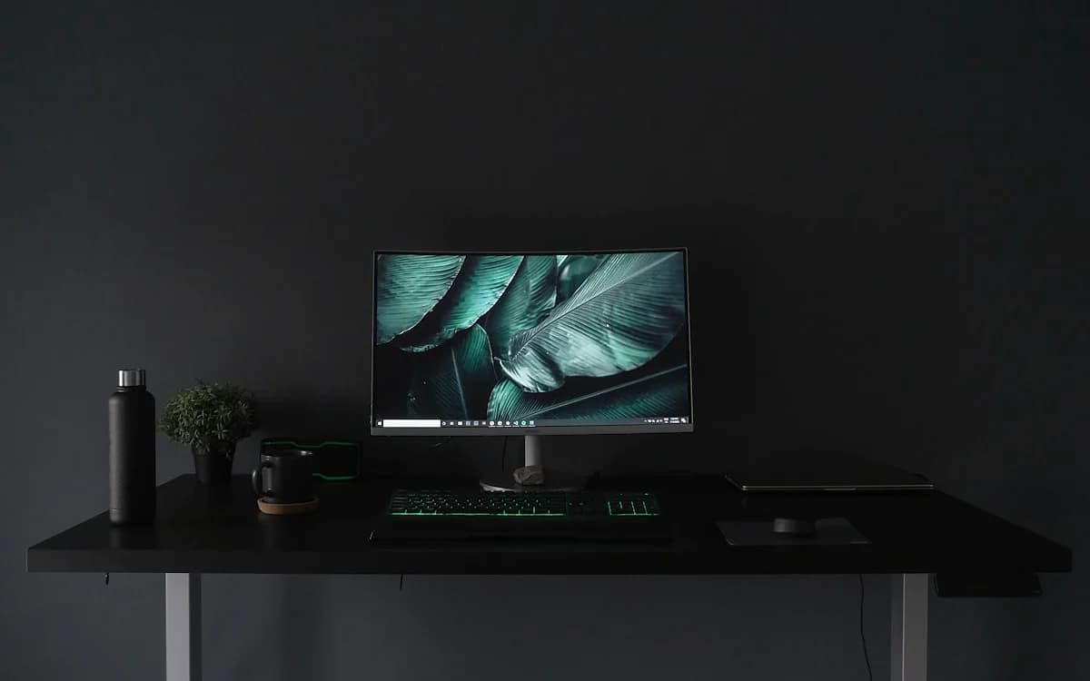 Melhor Mini PC para Jogos 1080p em 2026: Quanto Basta? Mesa escura com monitor, teclado com luz verde e mouse, montagem minimalista para jogar em Full HD