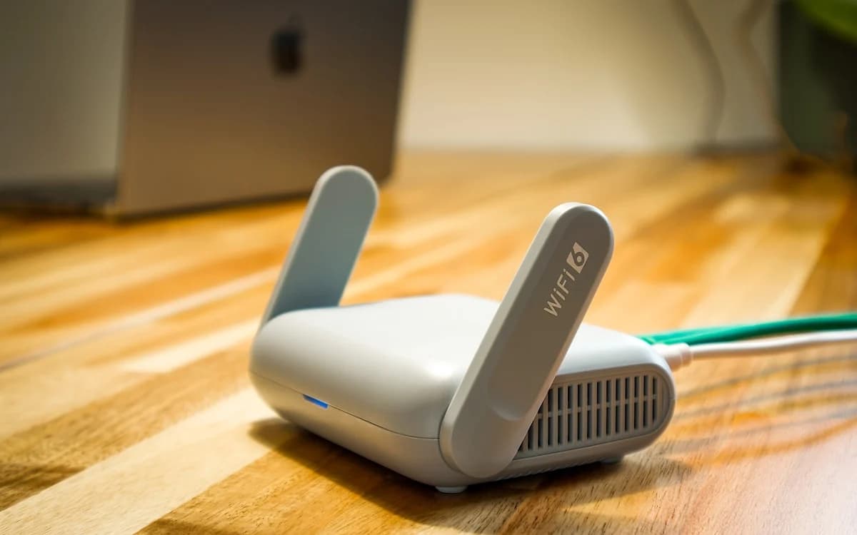 Melhor Repetidor de Sinal Wi-Fi em 2026 Repetidor de sinal Wi-Fi branco conectado numa tomada de parede em corredor de casa