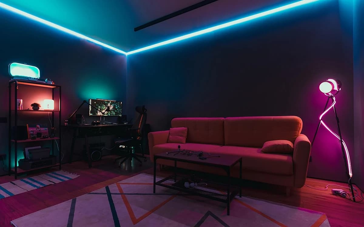 Mesa Gamer com LED RGB em 2026 Setup gamer em quarto escuro com LED RGB embaixo da mesa iluminando parede e periféricos sincronizados