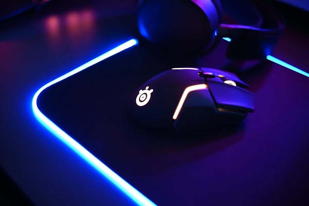 Mousepad de Vidro Vale a Pena? Vidro vs Tecido 2026 Mousepad de vidro temperado em setup gamer com mouse sobre superfície transparente e iluminação RGB