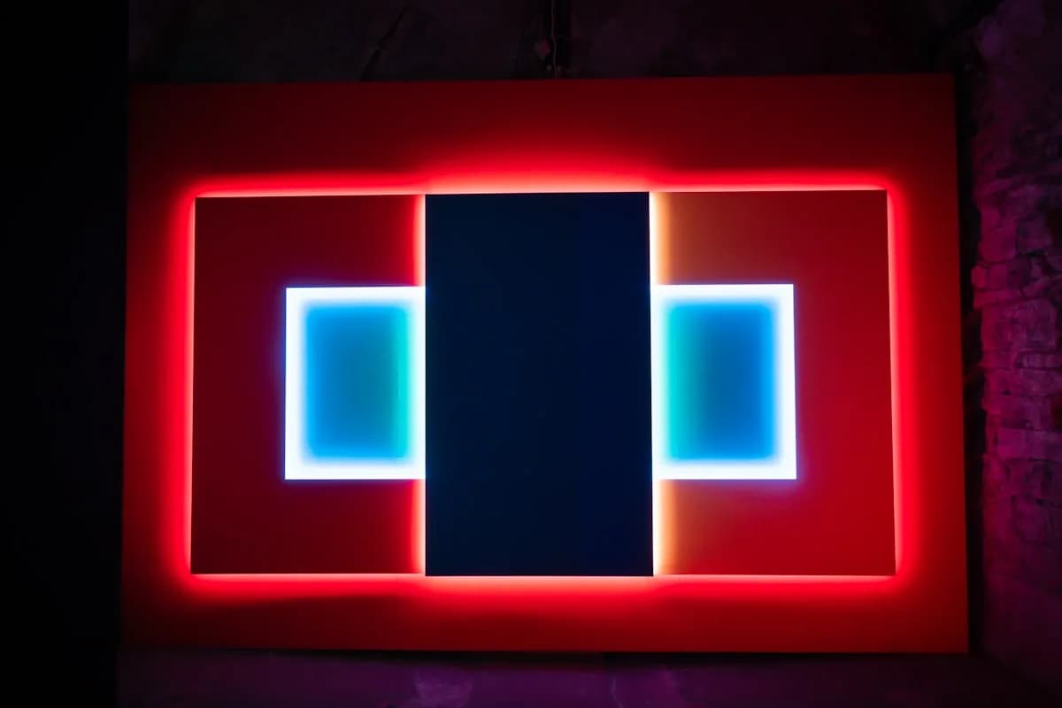 Painel de Luz Nanoleaf Vale a Pena em 2026 Painel retangular de luz com bordas vermelhas e recortes azuis acesos em ambiente escuro
