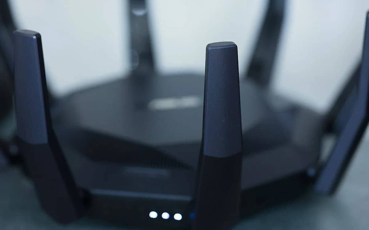 Roteador ou mesh: qual escolher para jogar em 2026 Roteador gamer e sistema mesh lado a lado sobre mesa com cabos de rede organizados