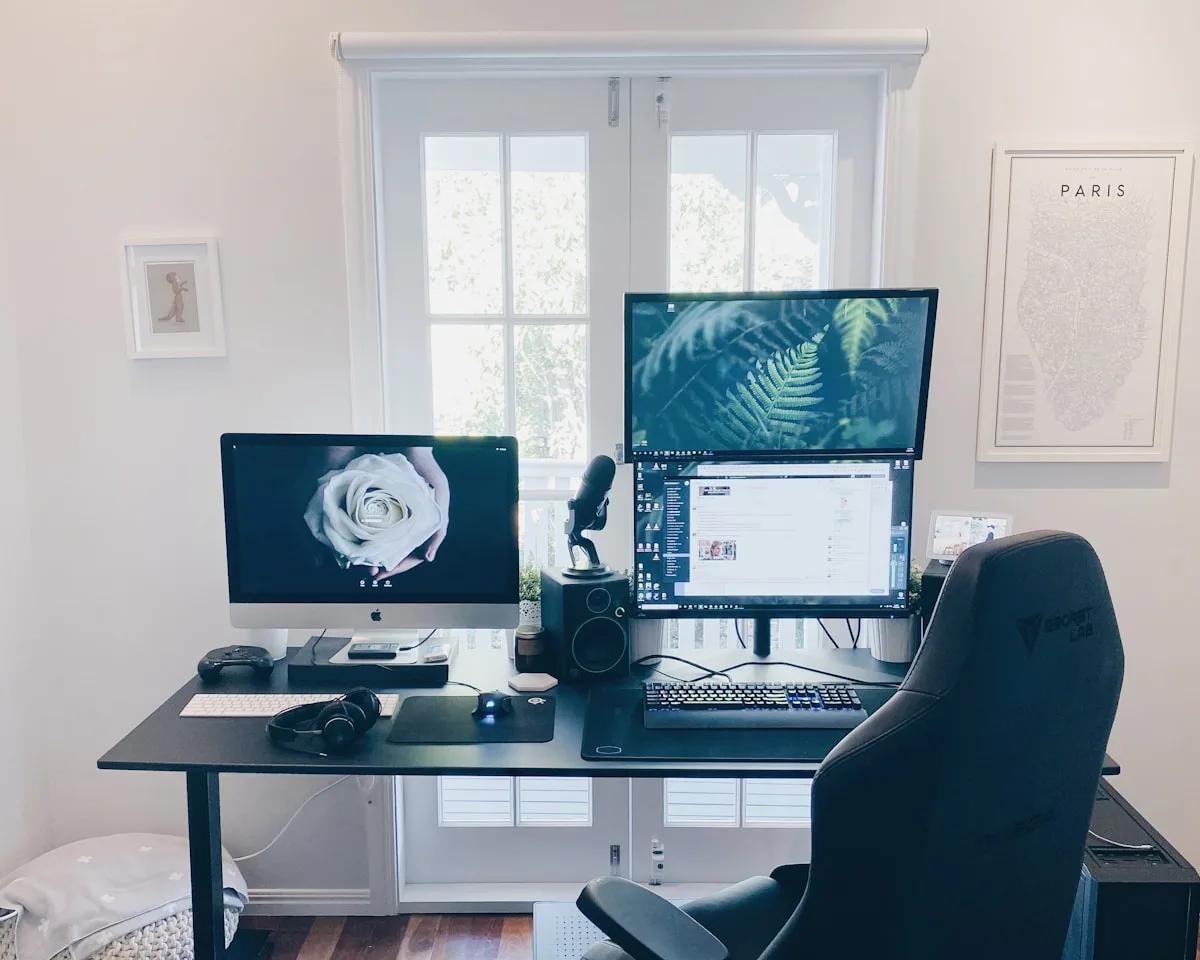 Suporte de Monitor Duplo Vale a Pena em 2026 Dois monitores lado a lado em mesa de home office com braços articulados erguendo as telas