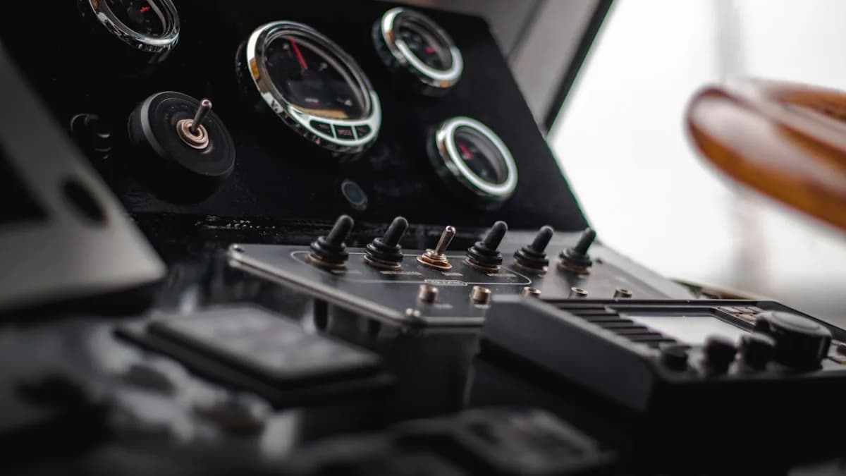 Thrustmaster Warthog Review: Vale a Pena em 2026? Painel de instrumentos analógicos com fileira de chaves seletoras metálicas em primeiro plano