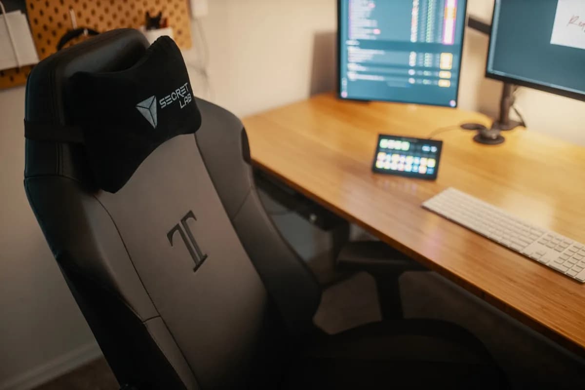 ThunderX3 TGC12 EVO Review 2026 Cadeira gamer de couro preta em setup gamer com monitor e mesa iluminada