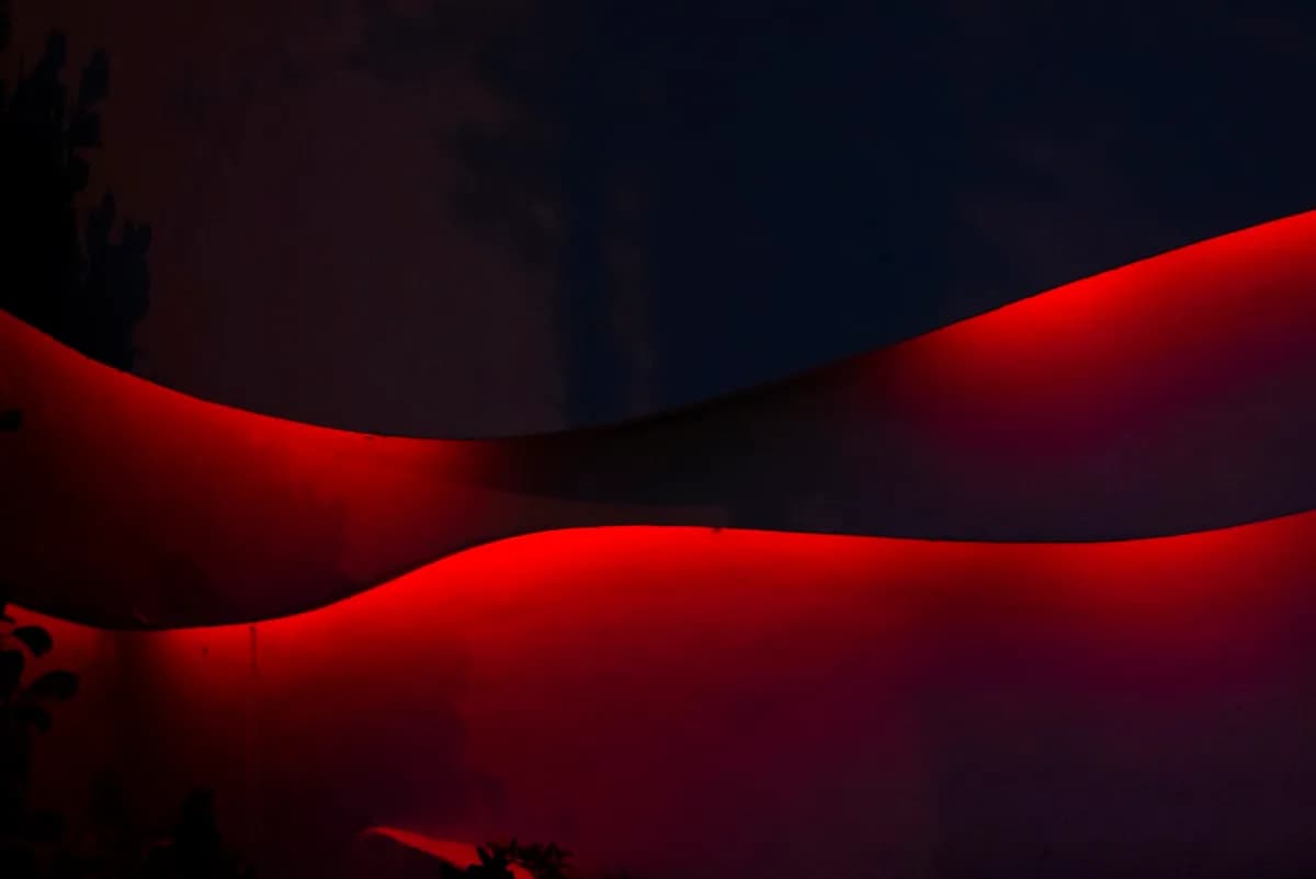 Tipos de Fita LED: RGB, RGBIC e ARGB Fita de LED vermelha iluminando o contorno de uma parede curva à noite, RGB de cor única