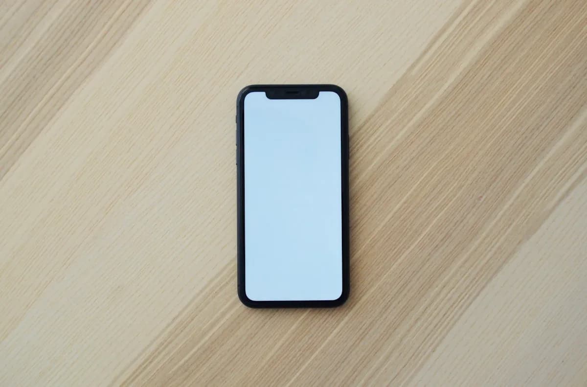 Vale a Pena Celular Recondicionado em 2026? Celular Android recondicionado sendo inspecionado em bancada com ferramentas de teste de tela e bateria