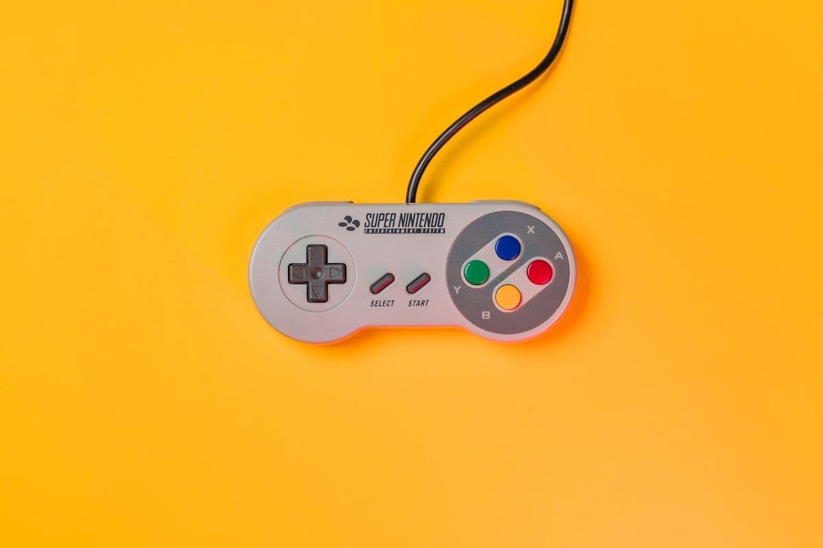 Controle Nintendo em fundo amarelo para jogos emuladores Controle Nintendo branco sobre superfície amarela, ideal para jogos emuladores