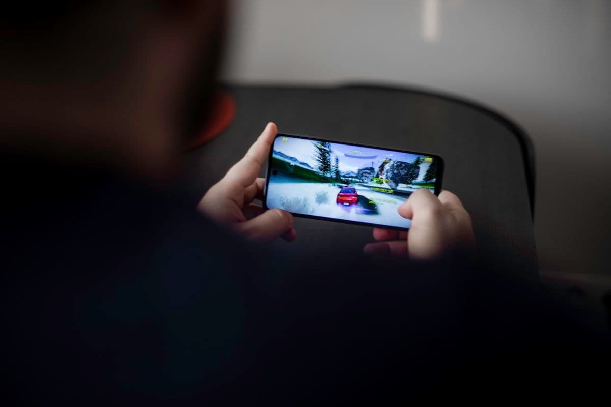 Dicas para jogar corrida grátis no Android e iOS Pessoa segurando smartphone Android preto jogando corrida grátis
