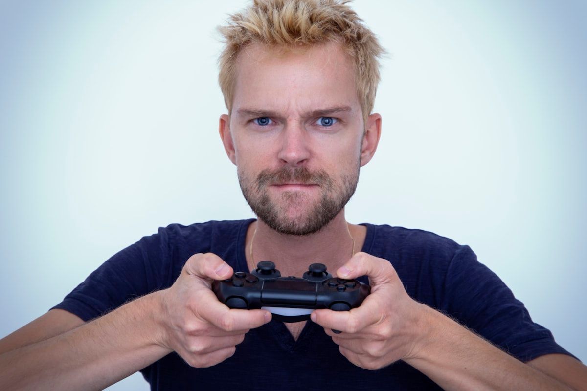 Homem com camisa de manga longa azul segurando uma pistola semi-automática preta, simbolizando estratégia no Valorant