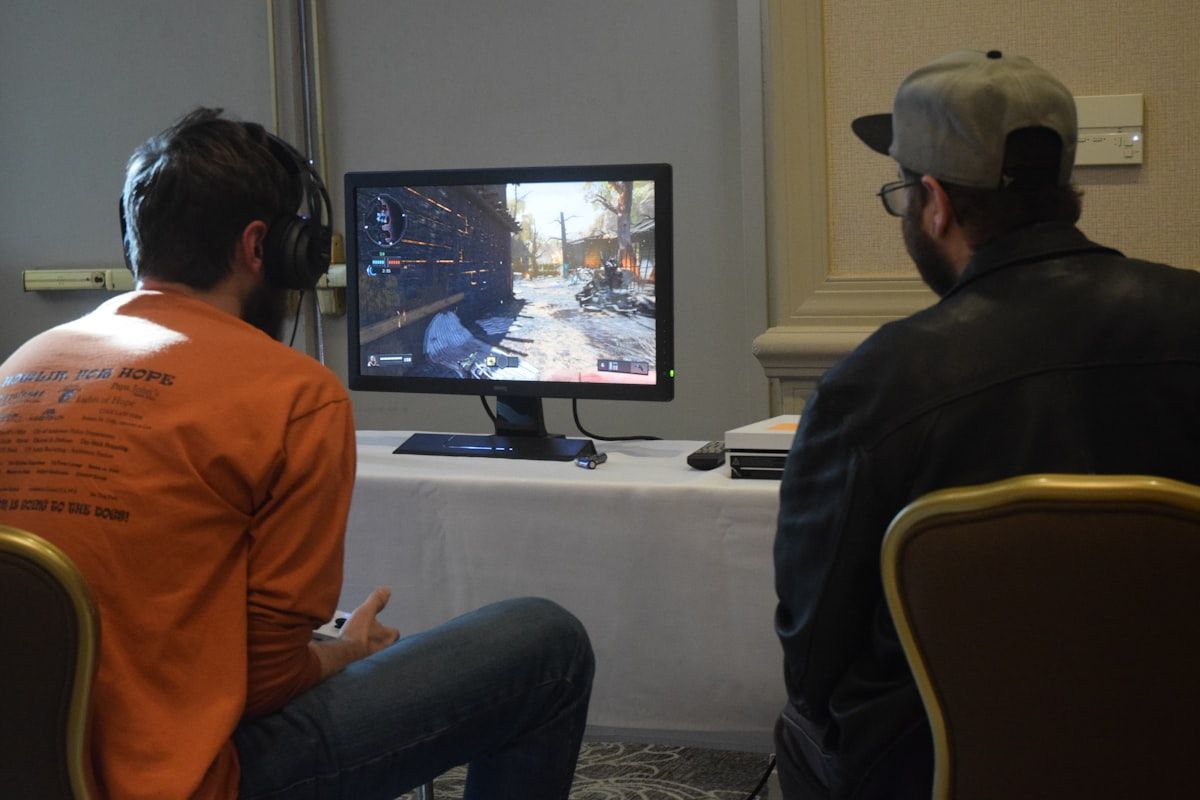Homens jogando CS2 e ajustando crosshairs Dois homens jogando CS2, focados na tela do monitor e ajustando crosshairs.