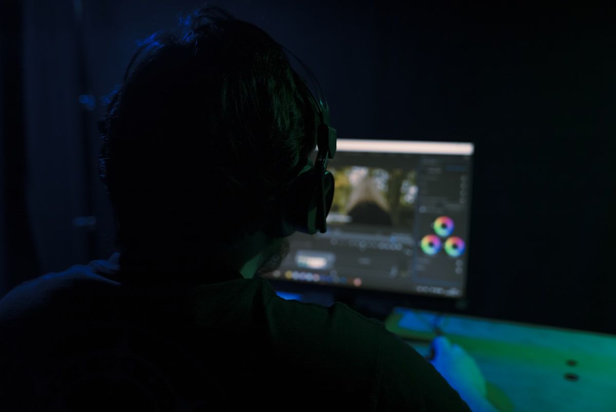 Homem analisando monitor de PC gamer para jogos Homem concentrado em frente a um monitor de PC gamer, analisando informações para melhorar sua experiência de jogo.