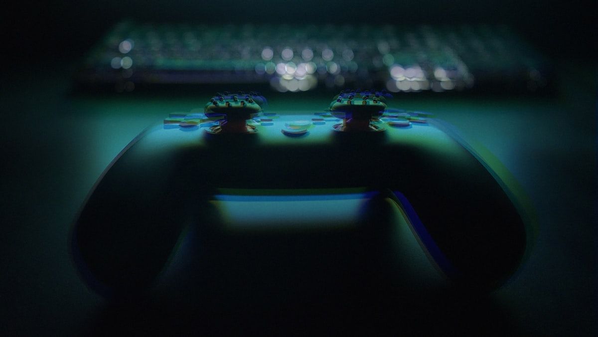 Controle de videogame e teclado em baixa luminosidade Controle de videogame e teclado em ambiente com pouca luz, ideal para gamers